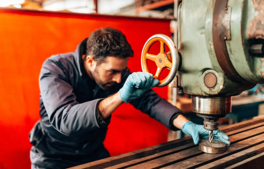Man operating industrial machinery in workshop.