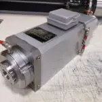 A compact industrial servo motor with attached encoder and wiring connections.