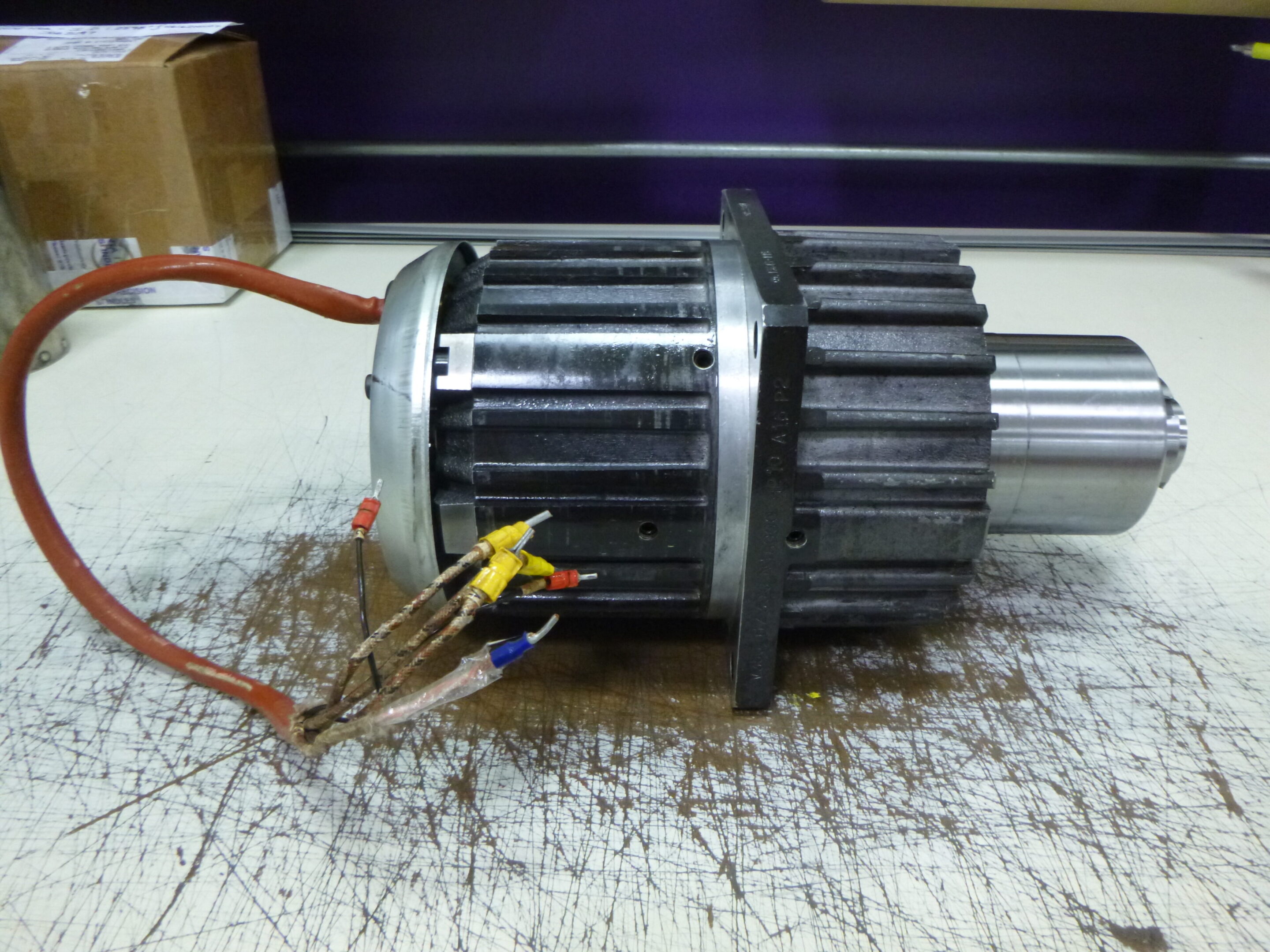 Disassembled motor with wiring on a workbench.