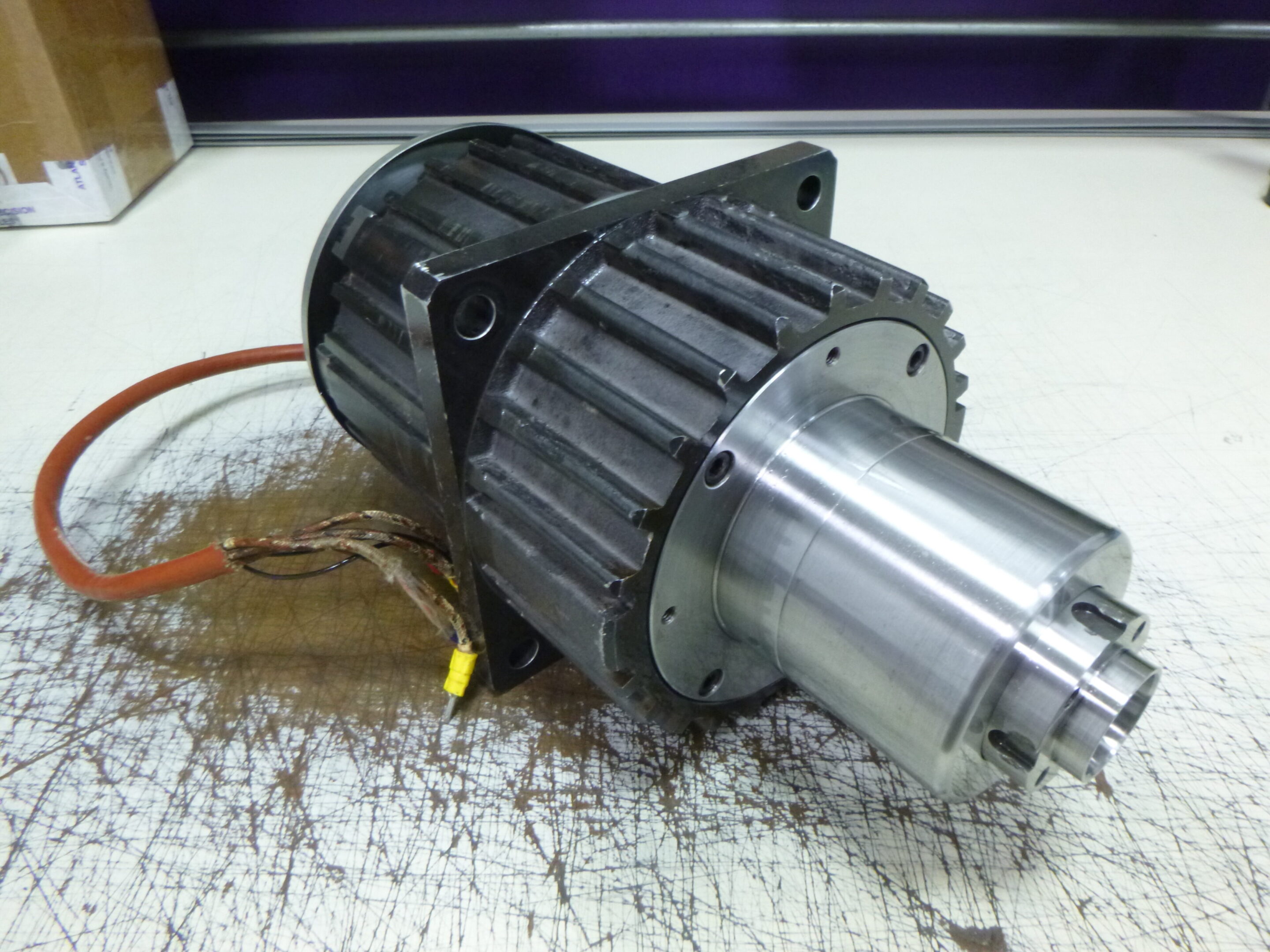 Close-up of a mechanical motor component on a workbench.