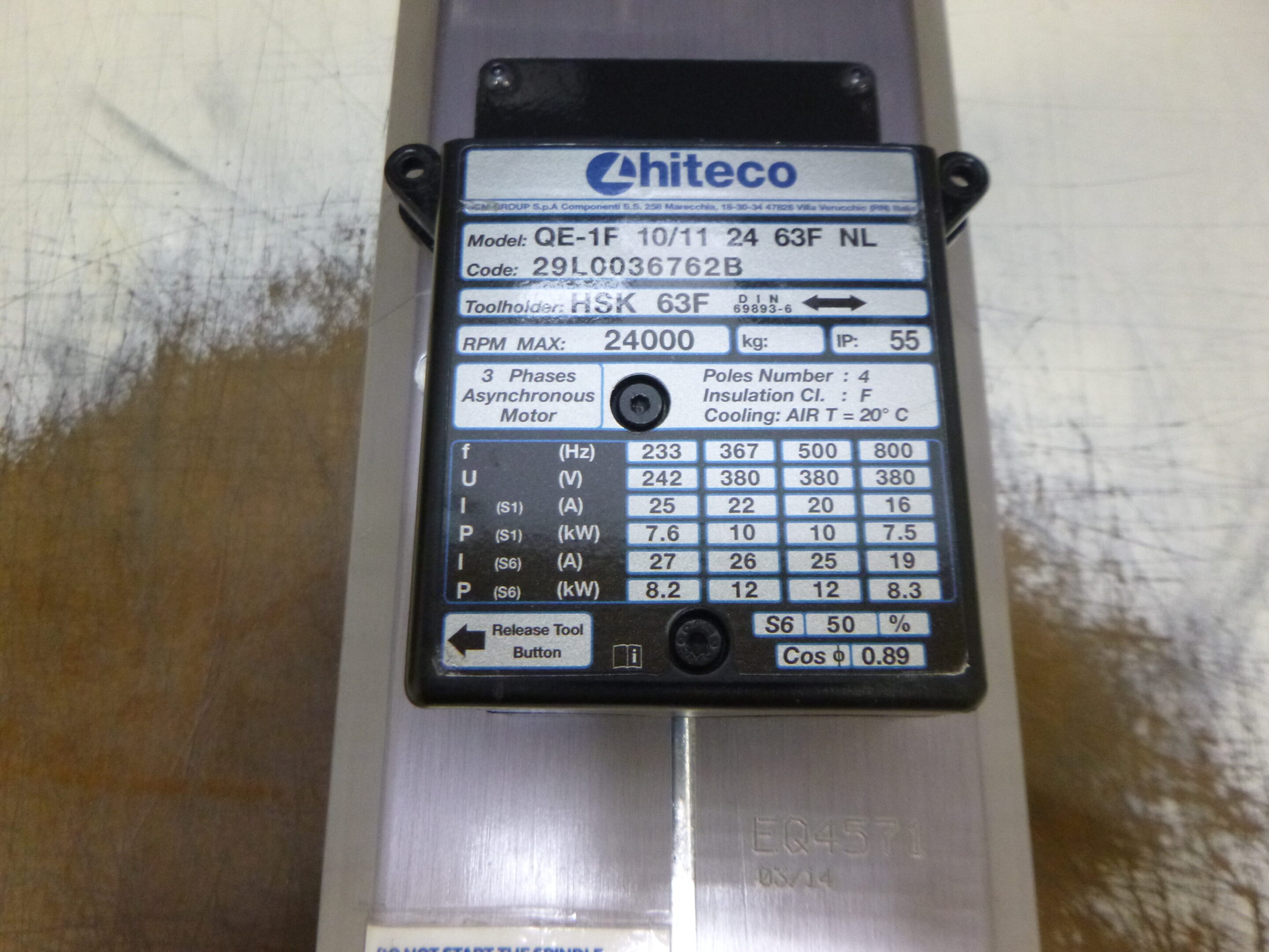 Metal equipment label with technical specifications and serial number.