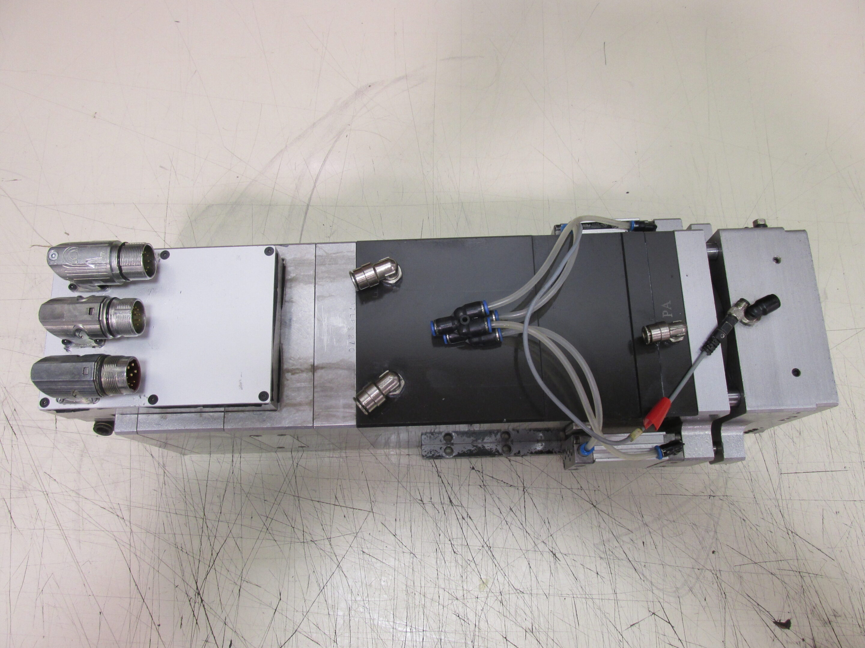 A disassembled electronic device with metal and plastic components on a white surface.