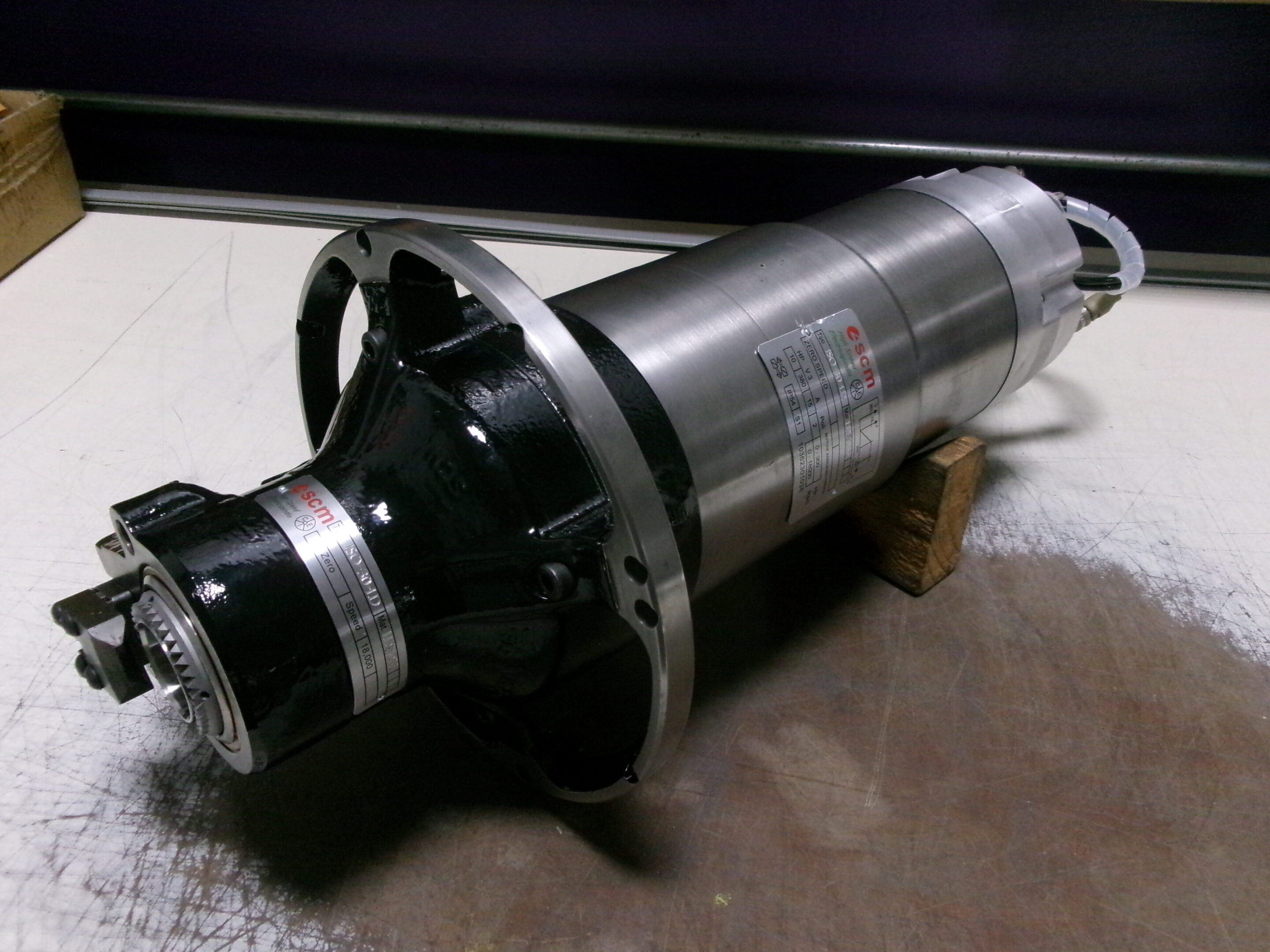 Close-up of a metal cylindrical industrial component on a workshop floor.